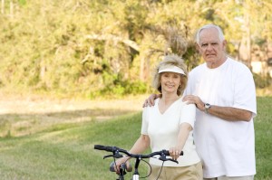 Older couple riding bikes in a beautiful park